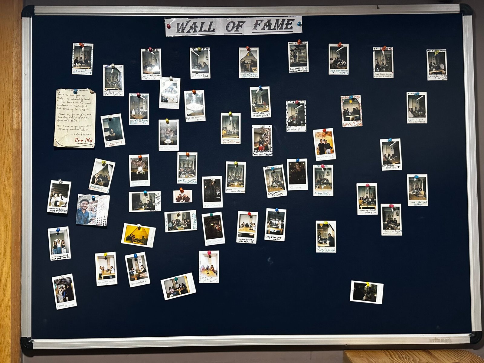 The Wall of Fame board covered in guest polaroids